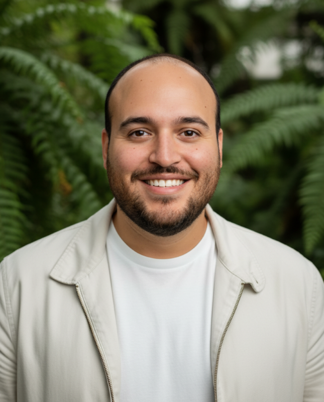 Alon Torres smiling, portrait with fern background